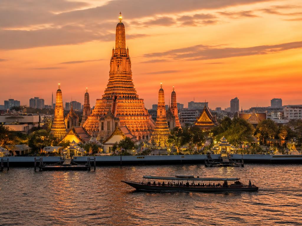Golden Thai temple spires against a Bangkok sunset