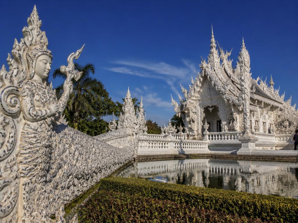 White temple and misty jungle mountains in northern Thailand